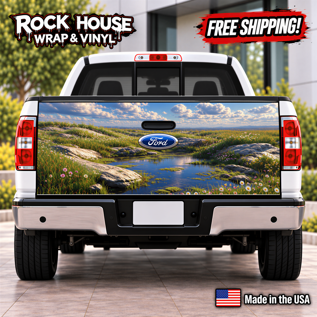 a white Ford truck with a large, colorful decal of a grassy field and water on the rear bumper.