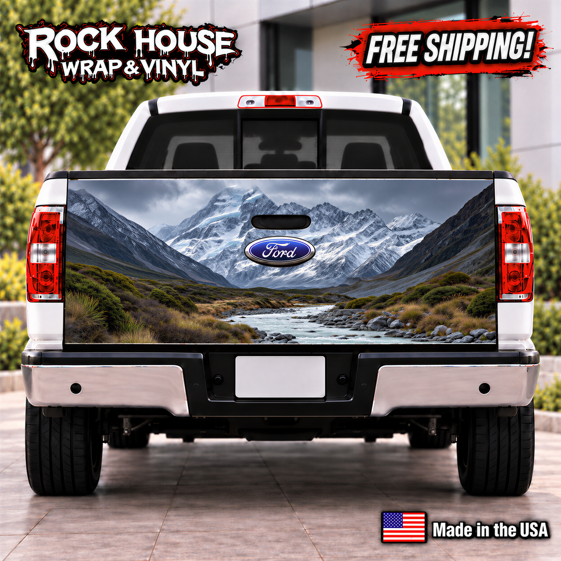 the rear of a white Ford truck with a large, detailed decal of a mountainous landscape on the tailgate.