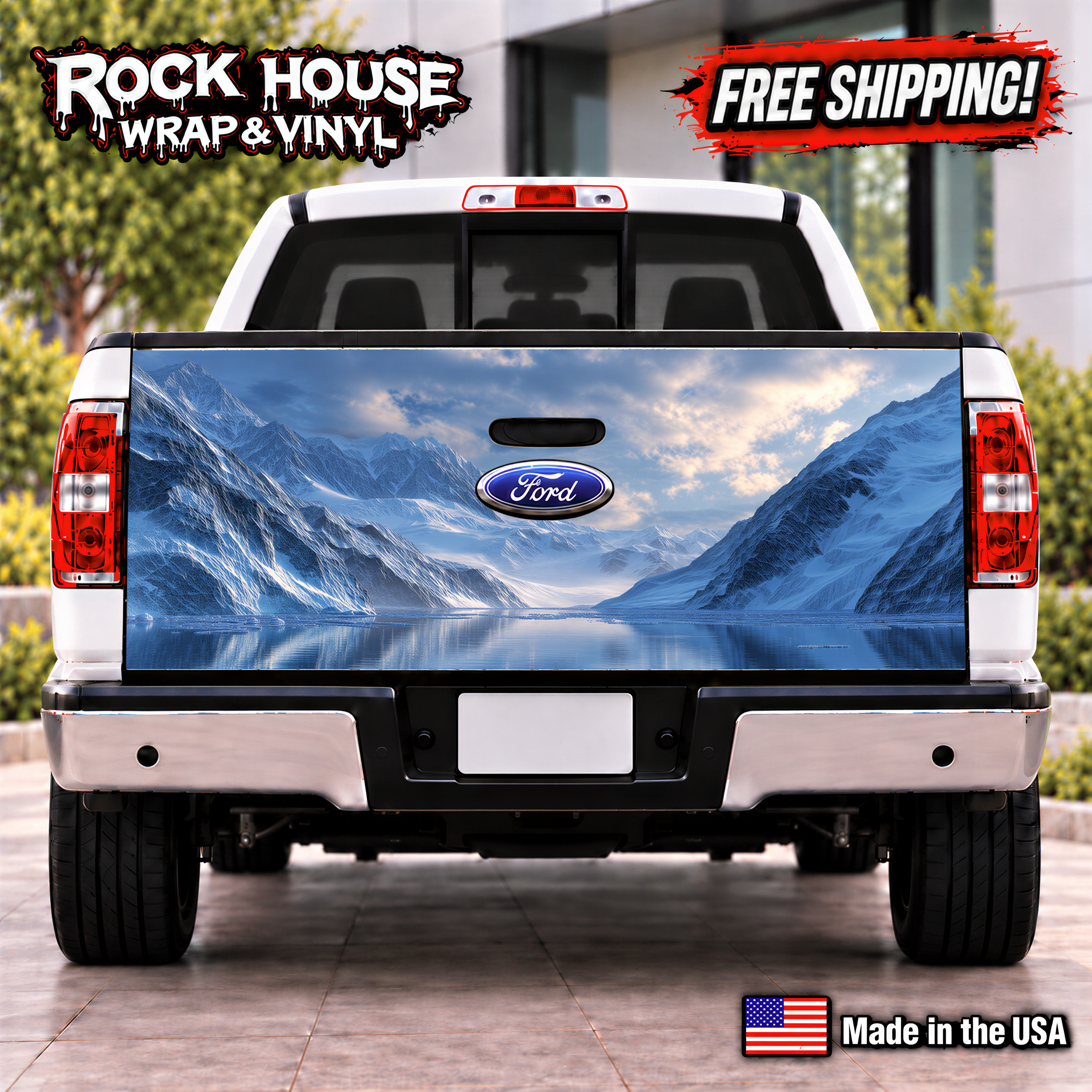 the rear of a white Ford truck with a large, detailed decal of a mountain landscape on the trunk. The truck is parked on a paved surface, and there is a sign that reads "Rock House Wrap & Vinyl" and "FREE SHIPPING!" indicating that the truck is being advertised for sale.